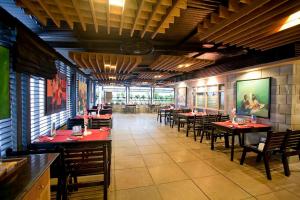 a dining room with tables and chairs in a restaurant at Well Park Residence Boutique Hotel & Suites in Chittagong