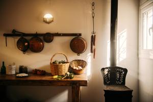 a table with baskets and pots and pans on a wall at Krasospito 1850 - a Corfiot Wine House Reborn in Lefkimmi