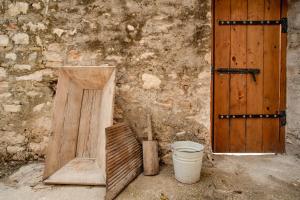 a wooden door and a bucket next to a building at Krasospito 1850 - a Corfiot Wine House Reborn in Lefkimmi