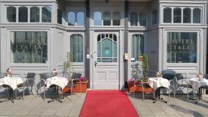 a restaurant with tables and chairs and a red carpet at Hotel Italia in Görlitz
