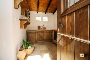 a kitchen with wooden cabinets and a door at Krasospito 1850 - a Corfiot Wine House Reborn in Lefkimmi