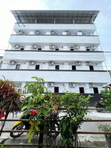 a tall white building with plants in front of it at Maluku Residence Syariah in Ambon