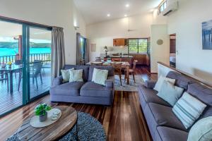 a living room with two couches and a table at Casuarina Cove 1 on Hamilton Island by HamoRent in Hamilton Island