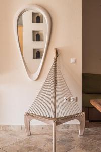 a rattan chair in front of a mirror at Fasolaki Skopelos - Eco Residences in Skopelos Town