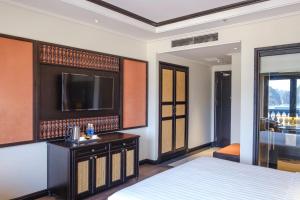 a bedroom with a bed and a flat screen tv at Green Dragon Boutique Hotel in Cẩm Phả