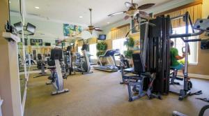 - une salle de sport avec un homme faisant de l'exercice dans la salle de sport dans l'établissement 610 -5-OC-Bungalow & pool at Watersong, à Davenport 33 autres photos