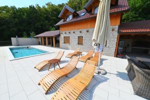 a group of chairs and an umbrella on a patio at Ruralna kuća Stela in Gornja Rijeka