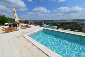 a swimming pool on a patio with an umbrella and chairs at Ruralna kuća Stela in Gornja Rijeka