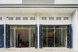 an entrance to a white building with sliding glass doors at Collection O Almasarra Residence Near Ring Road Medan in Medan
