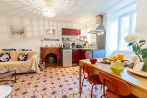 una cucina e un soggiorno con camino di La Maison dans les remparts a Sainte-Eulalie-de-Cernon Altre 11 foto