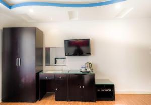 a room with a tv on a wall with a counter at Arima Hotel Nha Trang Beach by HC Group in Nha Trang