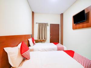 Postel nebo postele na pokoji v ubytování Hotel O Sean'S Residence Mansyur Near Universitas Sumatra Utara USU