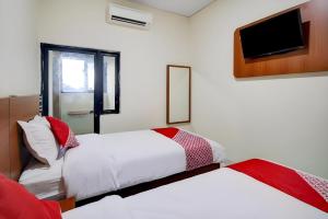 Postel nebo postele na pokoji v ubytování Hotel O Sean'S Residence Mansyur Near Universitas Sumatra Utara USU