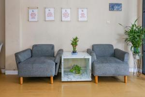 two chairs and a table with a plant in a room at Hotel O Tower Mahakam serviced apartment Riverview Jababeka in Bekasi
