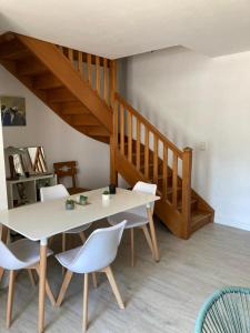comedor con mesa blanca y sillas blancas en La Chamade gîte Albi, en Terssac