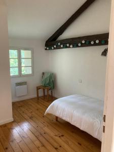 Un dormitorio con una cama blanca y una ventana. en La Chamade gîte Albi, en Terssac