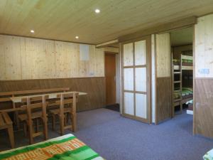 a room with wooden walls and a table and chairs at Chatová osada Ostaš in Police nad Metují