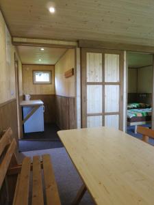 a room with a wooden table in a cabin at Chatová osada Ostaš in Police nad Metují +21 photos