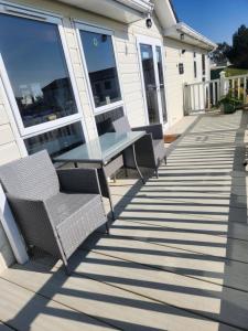 a patio with two chairs and a bench on a house at 40A Oak Village- 2 Bedroom Lodge on Grange Leisure Park in Mablethorpe
