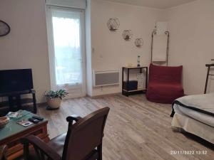 a living room with a bed and a red couch at Les Mesanges in Combrand +34 photos