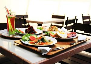 デンパサールにあるCollection O Near Bajra Sandi Monumen Formerly Grand Pondok Puri Ayuの食べ物と飲み物を盛り付けたテーブル