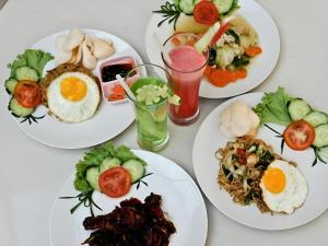 デンパサールにあるCollection O Near Bajra Sandi Monumen Formerly Grand Pondok Puri Ayuの食べ物や飲み物の皿が置かれたテーブル +45枚の写真