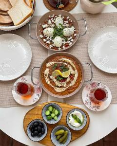a table topped with plates and bowls of food at Wadi Rum Hala camp in Wadi Rum +35 photos