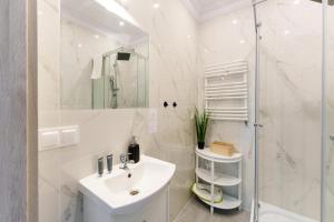 a white bathroom with a sink and a shower at Apartament 06 Blisko Plaży z Ogrodem - Grzybowo, Kołobrzeg - Nadmorska 26 in Grzybowo +5 photos