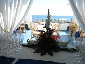 a table with wine glasses and flowers on it at Arathena Rocks Hotel in Giardini Naxos