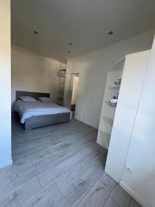 a bedroom with a bed and a wooden floor at Appartement calme et paisible au bord de la rivière in Ernée