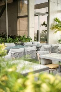 コロンボにあるSeSaya Poshtel & Bistroのテーブルと椅子と窓がある空のレストラン
