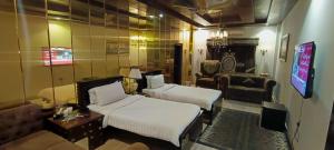 a hotel room with two beds and a couch at Royal Mansion Hotel in Multan