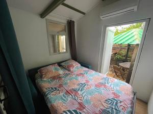 拉萨尔勒班Saline les bains petite maison bien aménagée calme & plage à pied的一间小卧室,配有床和滑动玻璃门