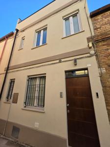 a building with a brown door and two windows at Maclas Apartment -Vasto Centro Storico- in Vasto