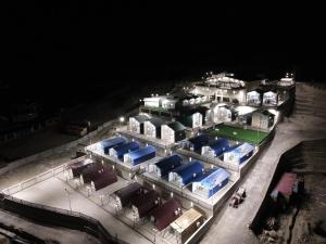 罕萨Lodges By Baron Hunza Attabad Lake的一座在晚上拥有蓝色屋顶的大型建筑