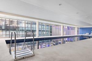 a swimming pool with a bench in a building at Harbourfront Urban Oasis in Melbourne
