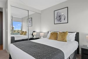 a white bedroom with two beds and a window at Harbourfront Urban Oasis in Melbourne +15 photos