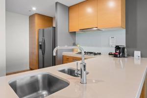 a kitchen with a sink and a refrigerator at Harbourfront Urban Oasis in Melbourne