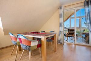 a dining room with a wooden table and chairs at Ferienwohnung Waldidyll in Wolgast