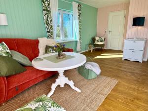 a living room with a red couch and a white table at Meridiamus 2 - Ferienhäuschen in Boddennähe in Ribnitz-Damgarten