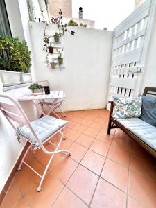 a balcony with a chair and a table and a bench at Casa Curiosa in Porto Torres