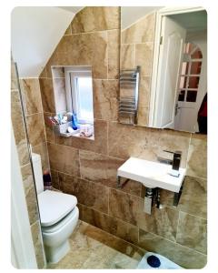 a bathroom with a toilet and a sink at 21 Fairfield Crescent in Edgware +6 photos