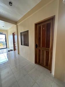 an empty room with a wooden door and a tile floor at Cris&Mar Homestay Extension in Burgos