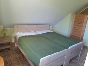 a bedroom with a large bed with a green bedspread at Naturhof-Goldbeck in Klütz