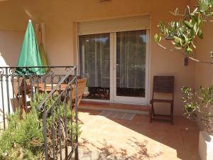 a patio with a sliding glass door and a chair at L'orangerai d'Antibes in Antibes