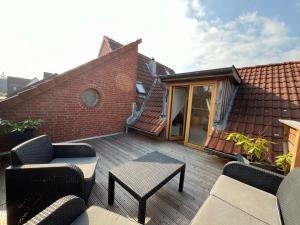 un patio avec des chaises et une table et un bâtiment dans l'établissement Ferienwohnung Tonne 1, à Eckernförde
