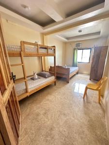 a bedroom with two bunk beds and a chair at Cris&Mar Homestay Extension in Burgos