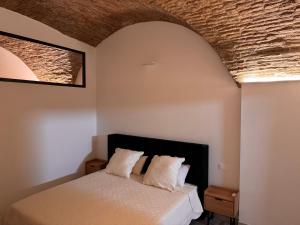 a bedroom with a bed with a brick ceiling at SottoAlCampanile in Campomarino