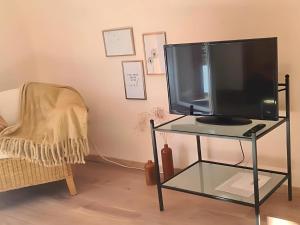 a tv on a glass table in a room with a chair at Apartment Pusteblume in Sankt Martin