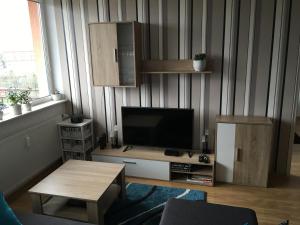 a living room with a television and a table at Apartament Slupsk in Słupsk